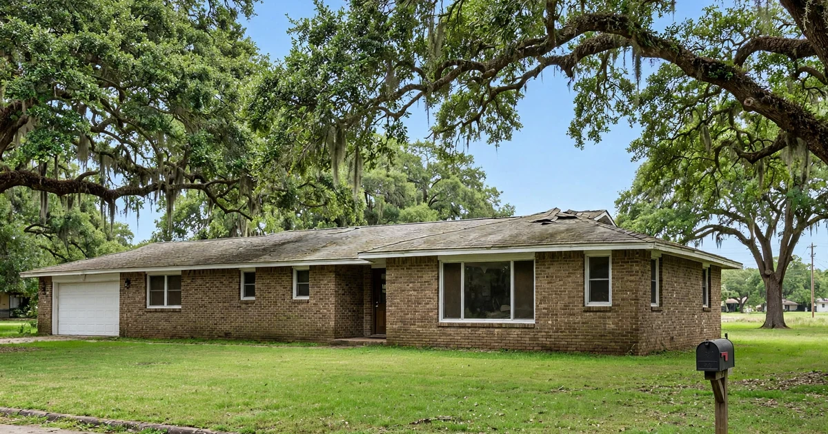 Allendale roof repair in Pasadena: ranch-style brick home with a few lifted shingles near the ridge line, mature oaks overhead, clear blue sky
