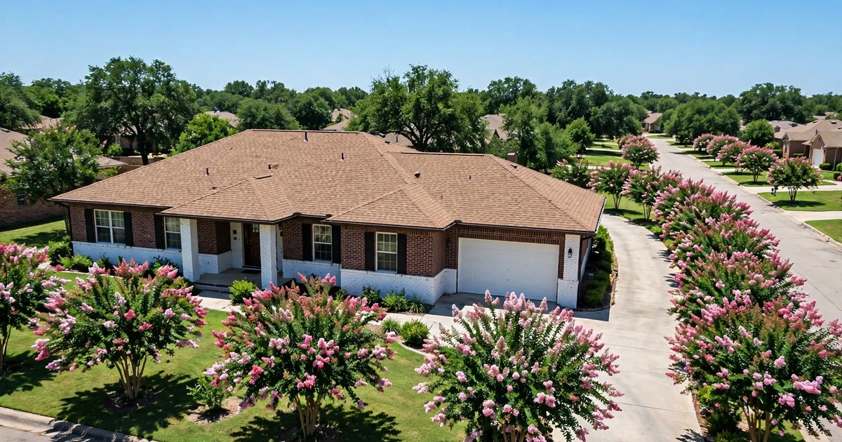 El Jardin del Mar roof repair in Pasadena: slightly elevated view of a brick ranch with mission-brown architectural shingles and crepe myrtles, clear sky