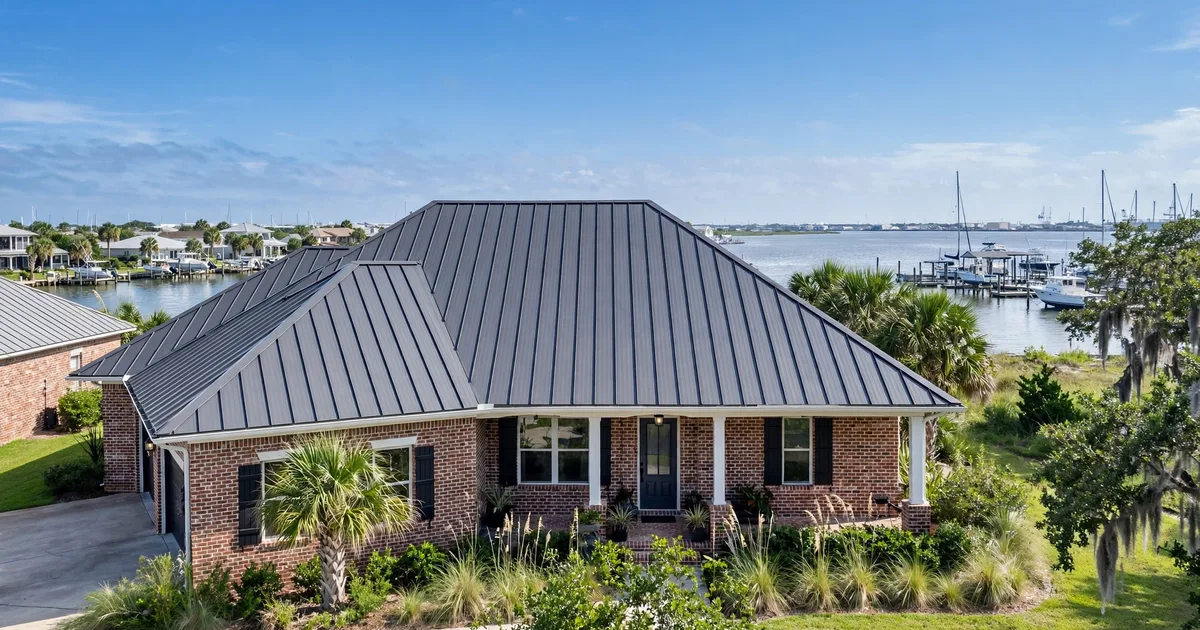 Metal roofing in Marina Bay, League City: standing-seam metal roof glowing at golden hour over a suburban home