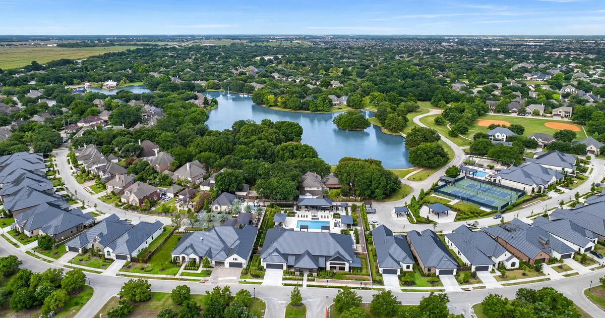 Metal roofing in New Territory, Sugar Land: standing-seam metal roof glowing at golden hour over a suburban home